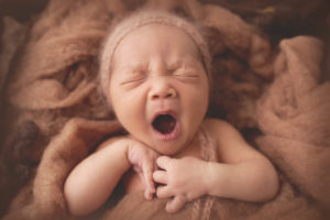 picture of a baby yawning during his newborn session with joanna booth photography