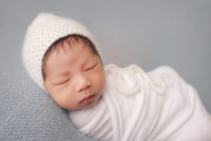 A newborn baby sleeping peacefully during a studio newborn session with Joanna Booth Photography!