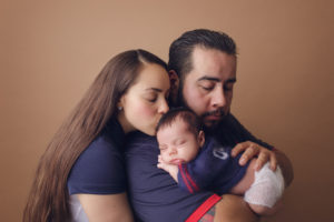 A portrait of a family holding their newborn son during a portrait session with Joanna booth Photography in katy Texas.