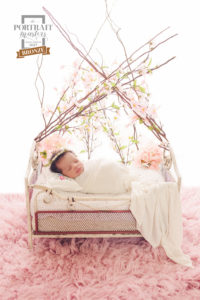 Little newborn in an iron bed looking like sleeping beauty