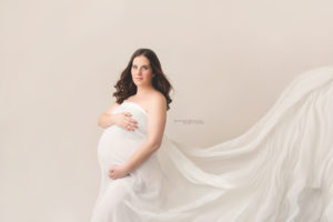 Beautiful expecting mom posing for Joanna Booth Photography in the studio.