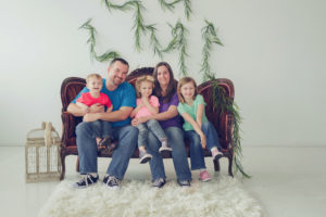 Family of 5 sitting on a vintage couch during a professional photo session by Joanna Booth Photography. Joanna is in Katy, Texas and serves the Katy and Houston, Texas areas.