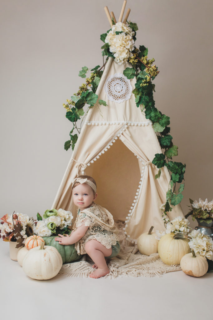 A photo captured by Joanna booth photography of a one year old surrounded by pumpkins